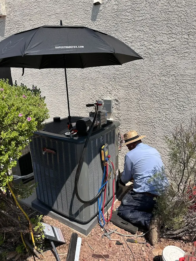HVAC technician performing outdoor AC maintenance in Asbury